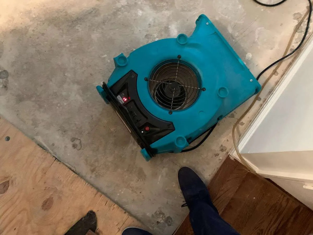 Air mover drying subfloor during Commercial Water Damage Restoration in Amsterdam